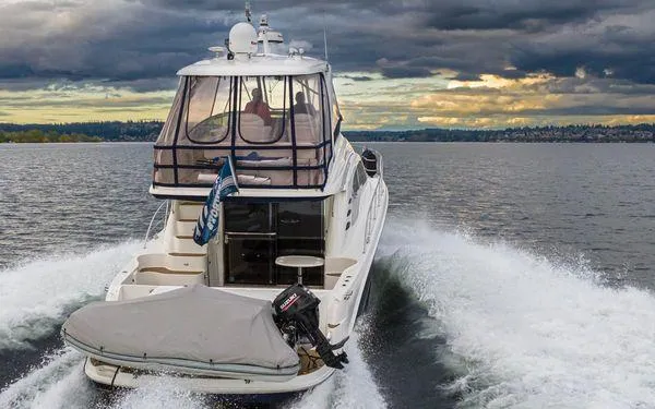Slide: The Image of 2005 Sea Ray 520 Sedan Bridge cruising on a lake under dramatic cloudy skies. - 5
