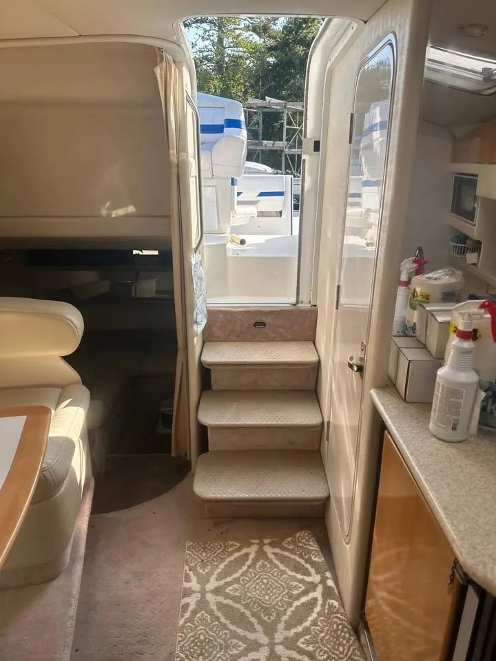 Slide: The Image of Interior of a 2002 Formula 31 PC boat, featuring stairs, seating, and kitchenette. - 4