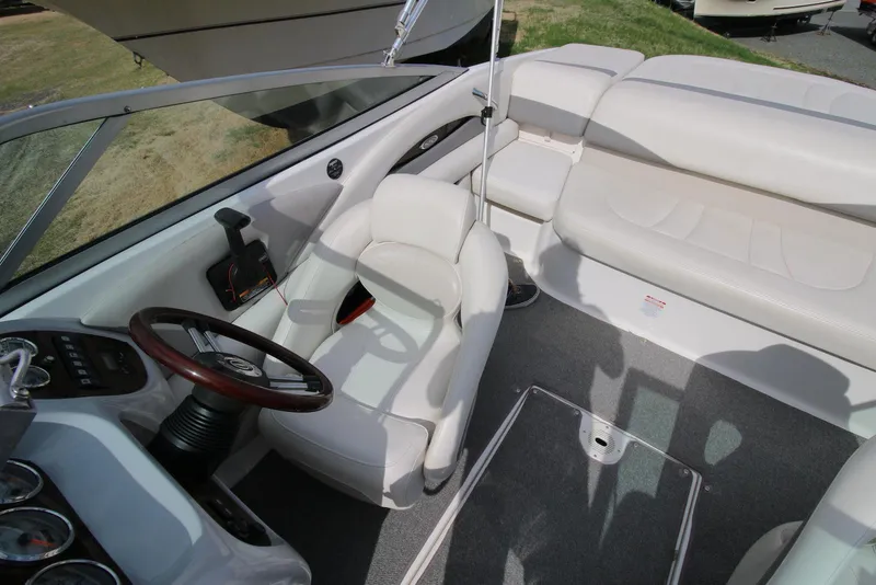Slide: The Image of 2007 Chaparral 204 SSi boat interior with white seating and wood-accented steering wheel. - 2