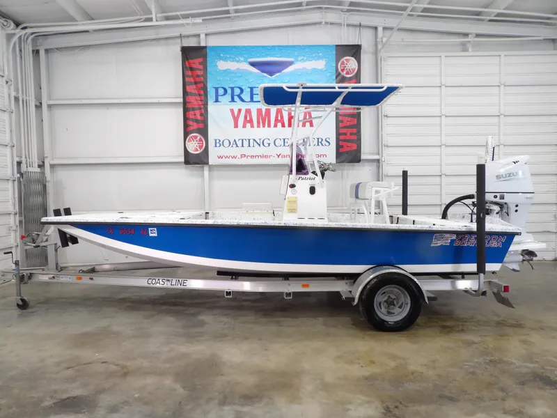 Slide: The Image of 2022 Freedom 18 Patriot boat on trailer in indoor showroom. - 1