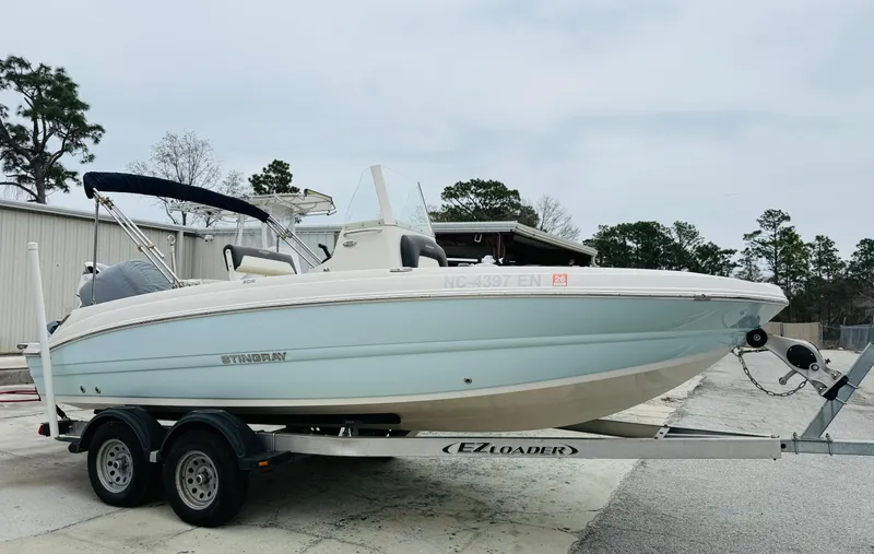 Slide: The Image of 2019 Stingray 206 CC boat on trailer, parked outdoors. - 1