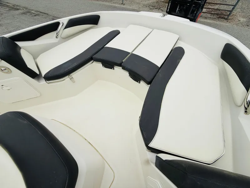 Slide: The Image of 2019 Stingray 206 CC boat interior with black and white cushioned seating. - 2