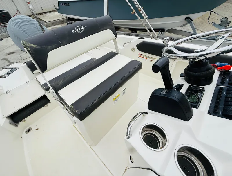 Slide: The Image of 2019 Stingray 206 CC boat interior with seating and control panel. - 7