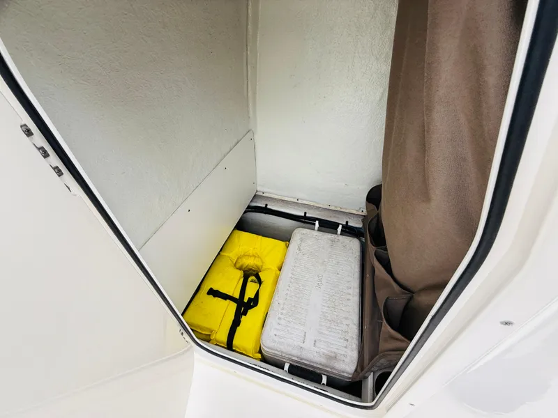 Slide: The Image of Storage compartment in a 2019 Stingray 206 CC boat with life jacket and equipment. - 8