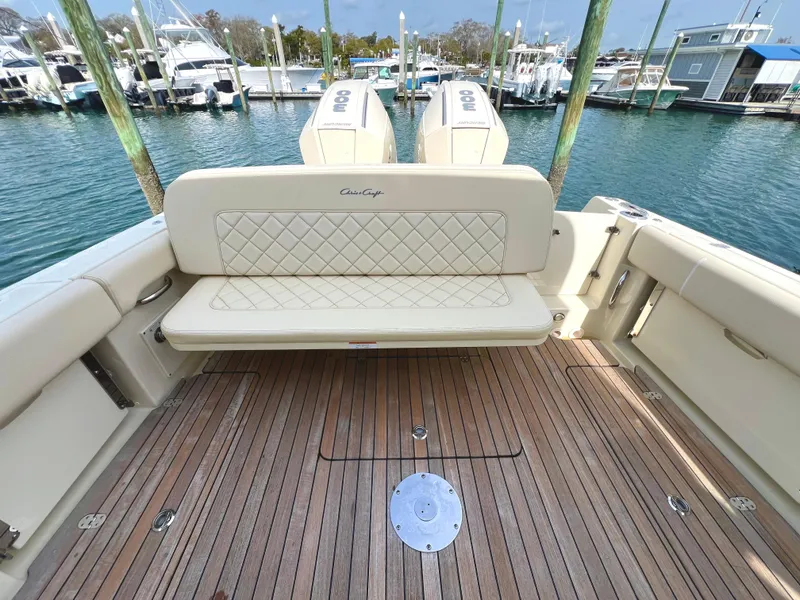 Slide: The Image of 2022 Chris-Craft Calypso 30 boat with teak deck and cushioned seating at marina. - 11