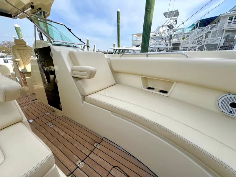 Slide: The Image of 2022 Chris-Craft Calypso 30 interior with beige seating and wooden deck. - 15