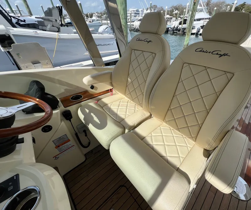 Slide: The Image of Luxurious 2022 Chris-Craft Calypso 30 boat interior with elegant cream seats and wooden accents. - 16