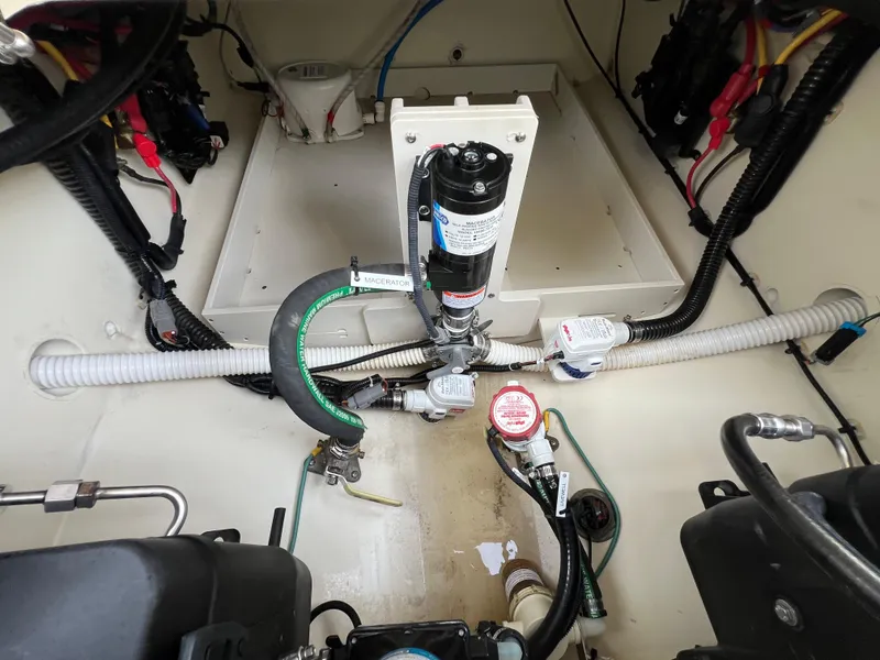 Slide: The Image of Engine compartment of 2022 Chris-Craft Calypso 30 with visible hoses and wiring. - 22