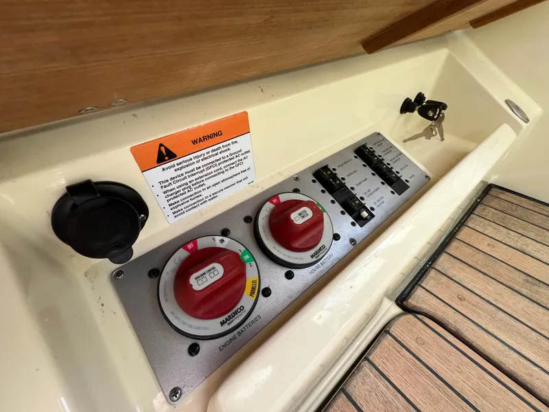 Slide: The Image of Control panel of 2022 Chris-Craft Calypso 30 boat with switches and warning label. - 23