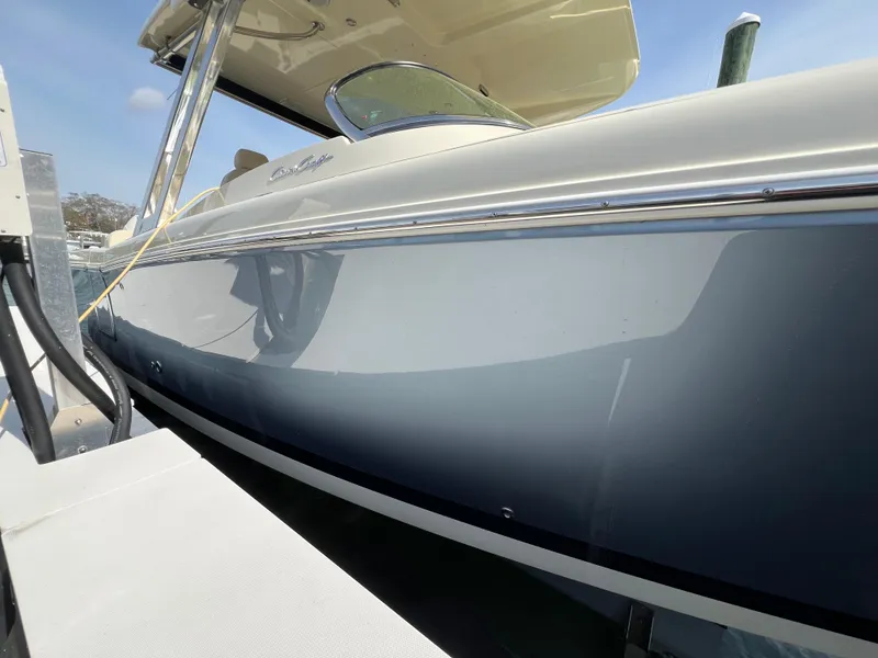 Slide: The Image of 2022 Chris-Craft Calypso 30 boat docked, showcasing sleek design and elegant blue hull. - 25