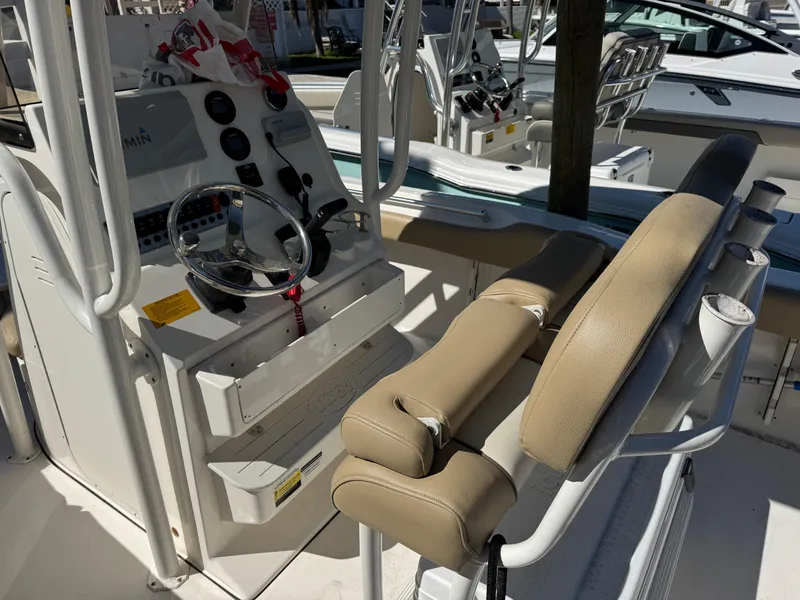 Slide: The Image of 2019 Key West 219 FS boat interior with steering console and beige seating. - 5