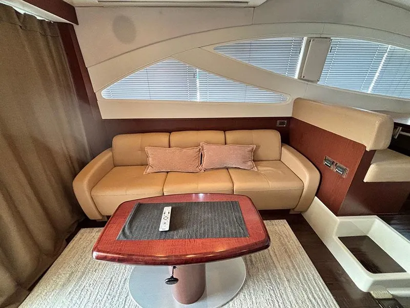 Slide: The Image of Luxurious interior of 2013 Sea Ray 450 Sedan Bridge yacht with beige sofa and wooden table. - 26