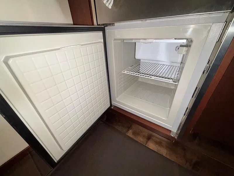 Slide: The Image of Open refrigerator inside 2013 Sea Ray 450 Sedan Bridge yacht, showcasing interior storage space. - 37