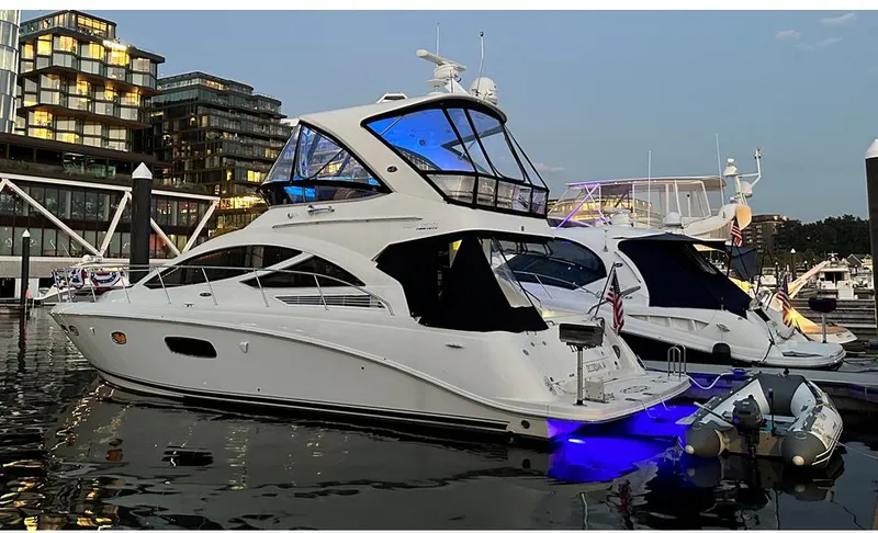Slide: The Image of 2013 Sea Ray 450 Sedan Bridge yacht docked at marina, illuminated with blue lights. - 4