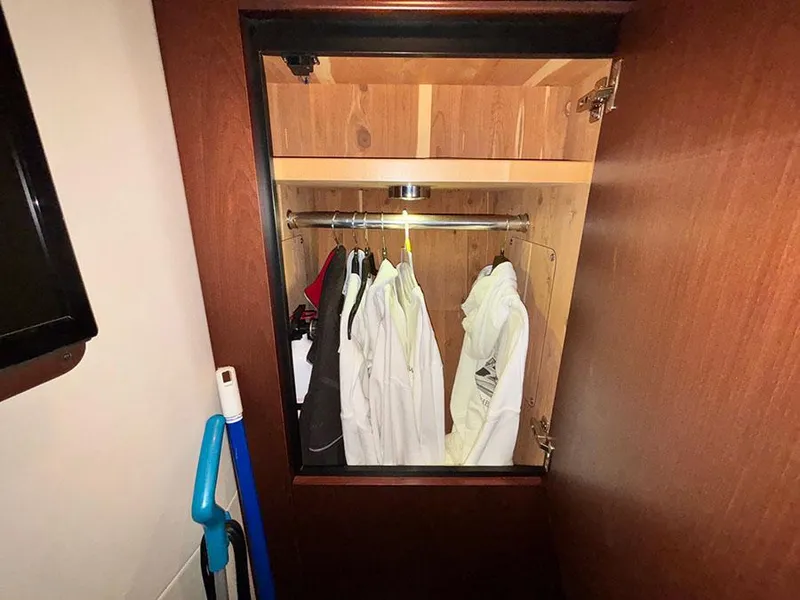 Slide: The Image of Closet interior on 2013 Sea Ray 450 Sedan Bridge with hanging clothes and cleaning tools. - 46