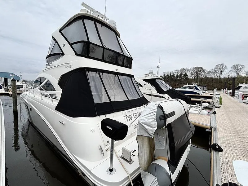 Slide: The Image of Sea Ray 450 Sedan Bridge 2013 yacht docked at marina, featuring sleek design and covered upper deck. - 7