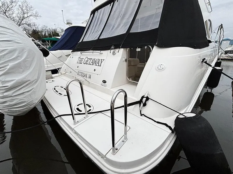 Slide: The Image of 2013 Sea Ray 450 Sedan Bridge docked, featuring rear deck and protective covers. - 8