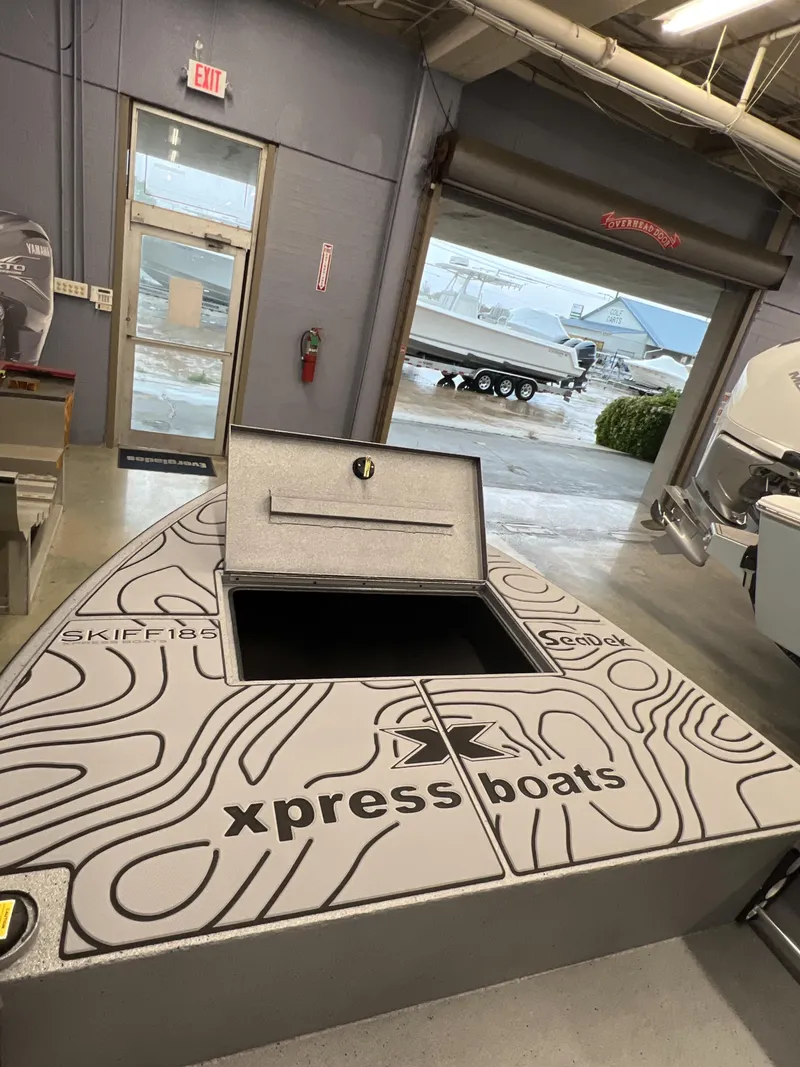 Slide: The Image of 2025 Xpress 185 Skiff boat interior with open storage compartment in showroom. - 4