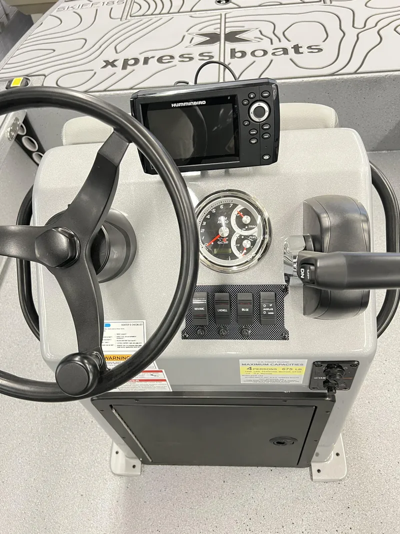 Slide: The Image of 2025 Xpress 185 Skiff boat dashboard with steering wheel and control panel. - 5