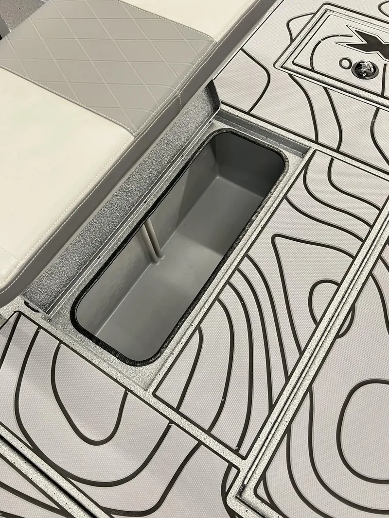 Slide: The Image of 2025 Xpress 185 Skiff boat interior with storage compartment and patterned flooring. - 6