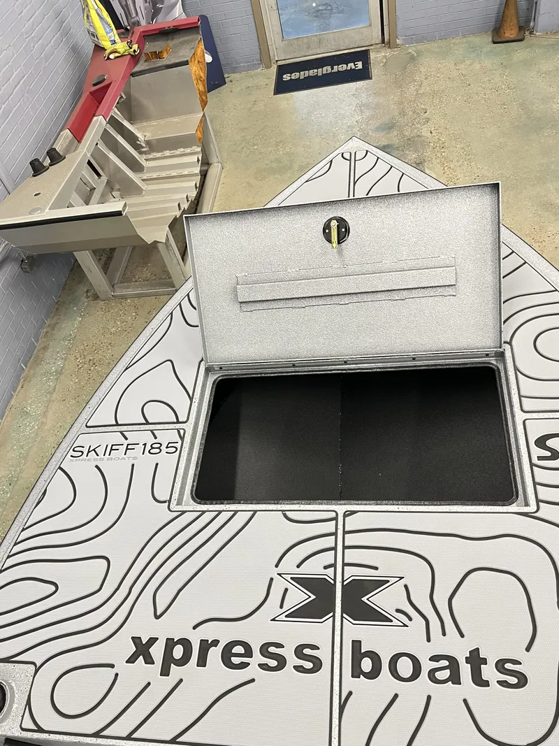 Slide: The Image of 2025 Xpress 185 Skiff boat with open storage compartment in showroom. - 8