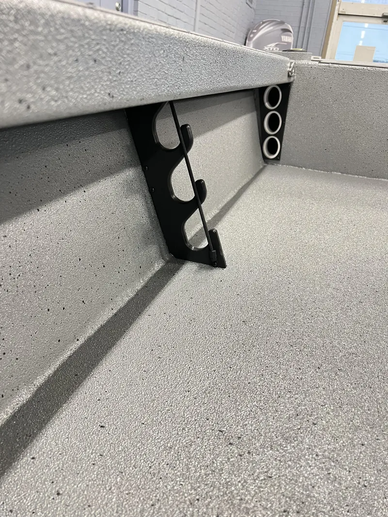 Slide: The Image of 2025 Xpress 185 Skiff interior with rod holders and textured flooring. - 9