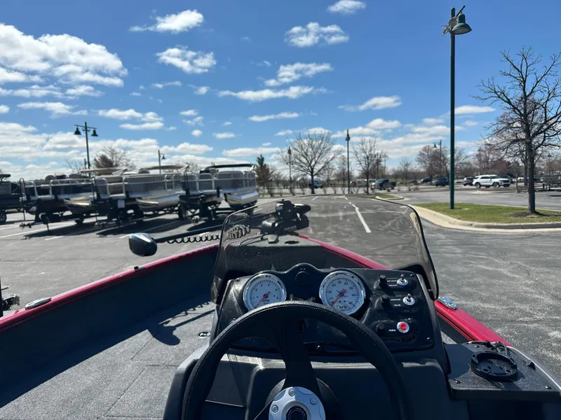 Slide: The Image of 2025 Tracker Super Guide V-16 SC boat dashboard in a parking lot under a blue sky. - 3