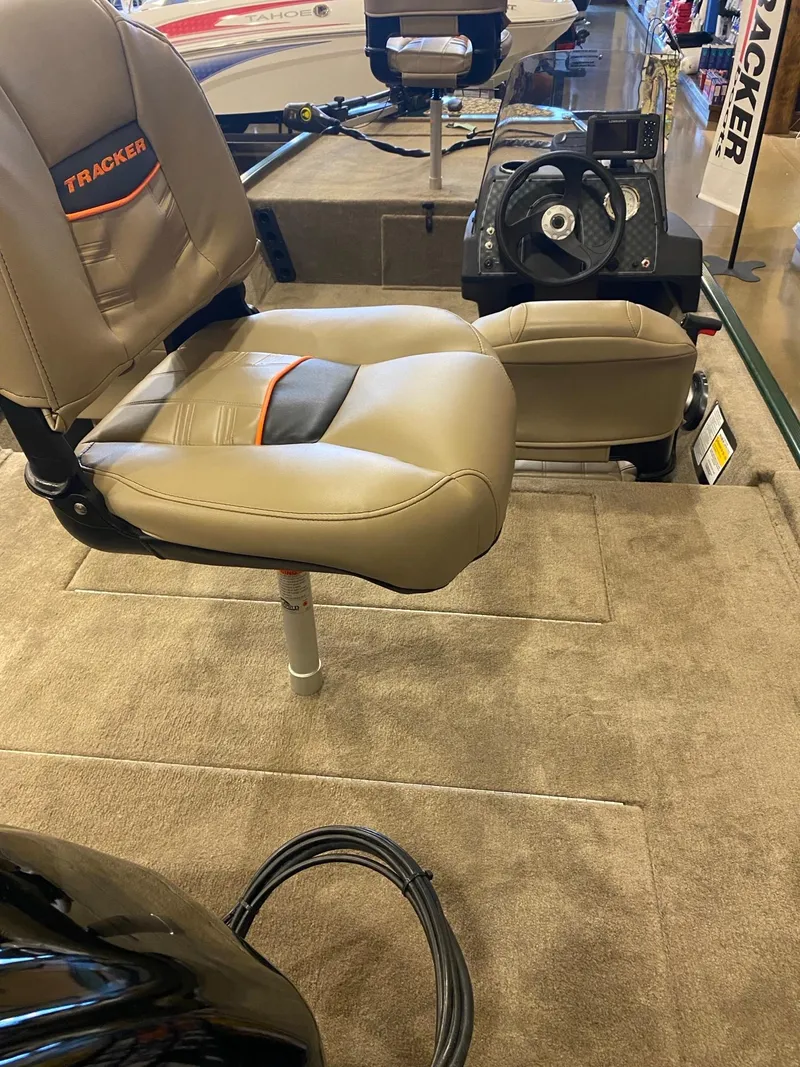 Slide: The Image of 2025 Tracker Bass Tracker Classic Limited boat interior with beige seating and steering wheel. - 2