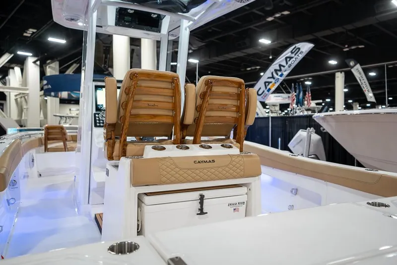 Slide: The Image of 2025 Caymas 291 HB boat interior with cushioned seating and modern design at a boat show. - 13