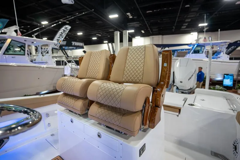 Slide: The Image of 2025 Caymas 291 HB boat with luxurious tan quilted seats at a boat show. - 14
