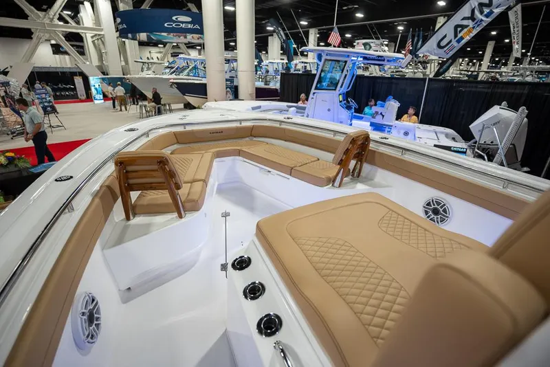 Slide: The Image of 2025 Caymas 291 HB boat interior with tan seating at a boat show. - 15