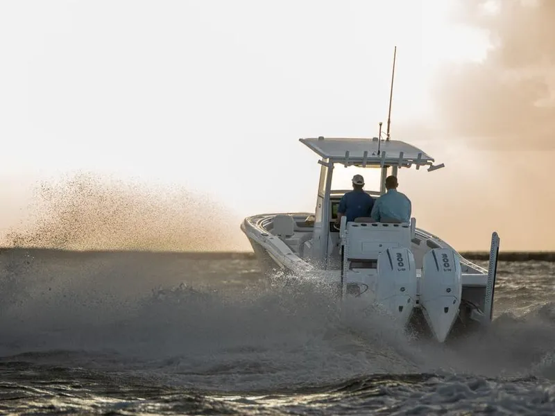 Slide: The Image of 2025 Caymas 291 HB boat navigating through waves at sunset. - 4