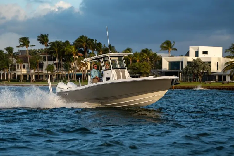 Slide: The Image of 2025 Caymas 291 HB boat cruising on water near modern waterfront homes. - 5