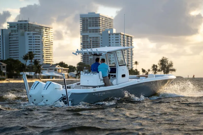 Slide: The Image of 2025 Caymas 291 HB boat cruising near city skyline at sunset. - 6