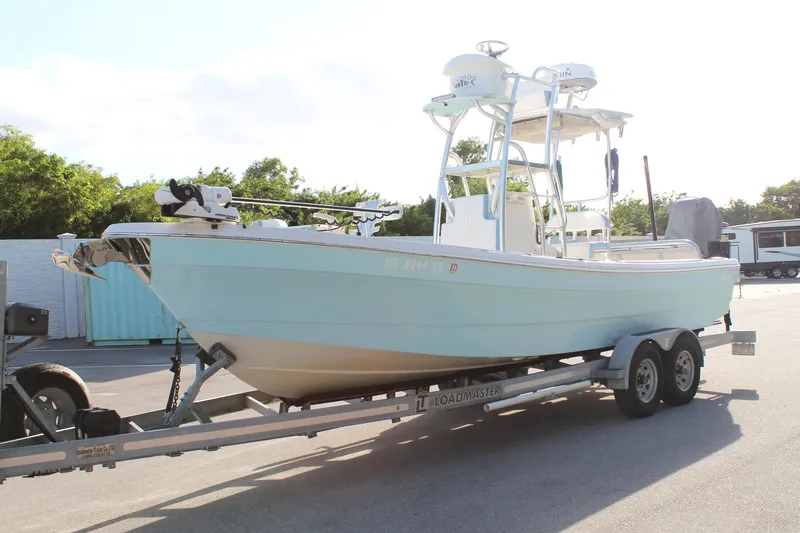 The Image of 2018 Andros 26 Tarpon boat on trailer, light blue hull, parked outdoors. - 1