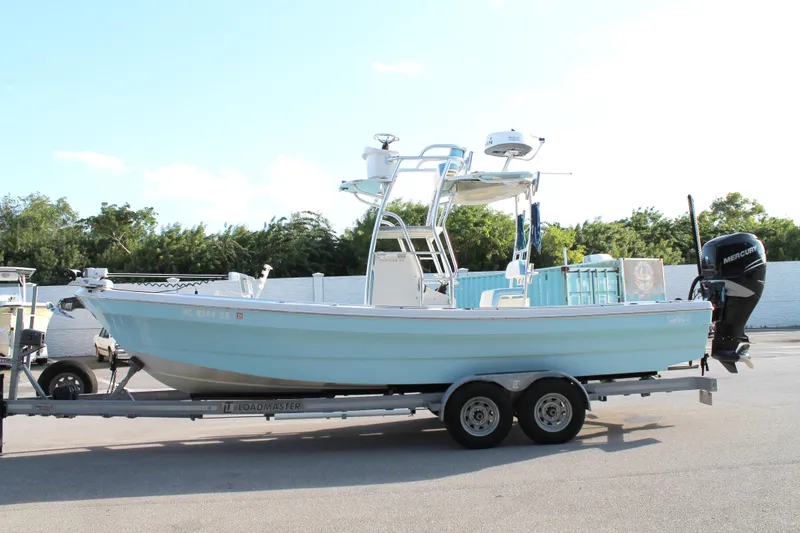 Slide: The Image of 2018 Andros 26 Tarpon boat on trailer, light blue hull, parked outdoors. - 2