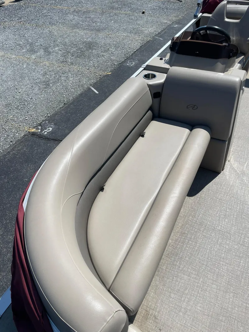 Slide: The Image of 2021 Avalon GS Quad Lounger boat interior with beige seating and steering console. - 11