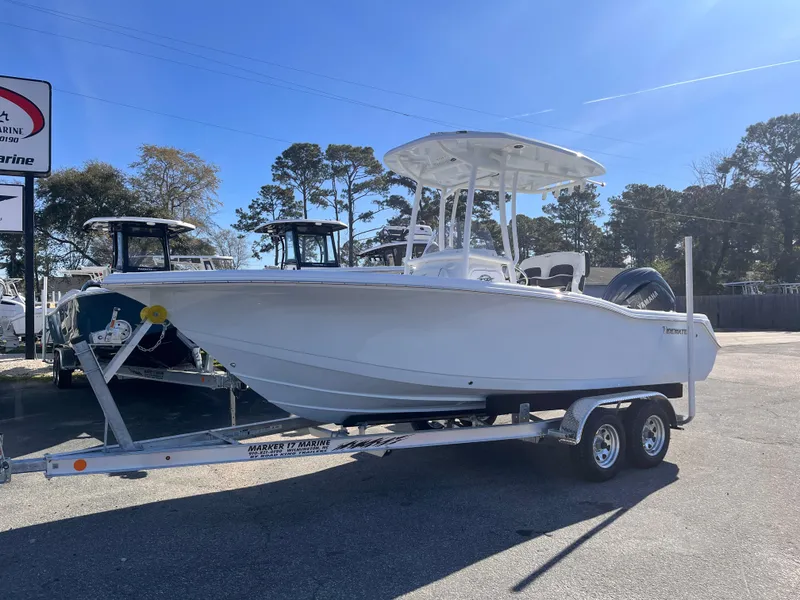 Slide: The Image of 2025 Tidewater 210 CC Adventure boat on trailer, parked outdoors under clear sky. - 1