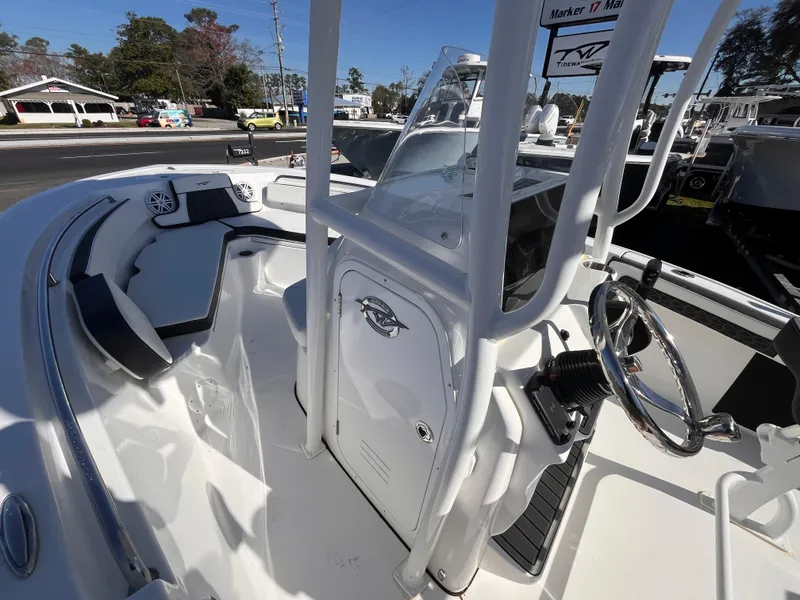 Slide: The Image of 2025 Tidewater 210 CC Adventure boat interior with steering wheel and seating area. - 10