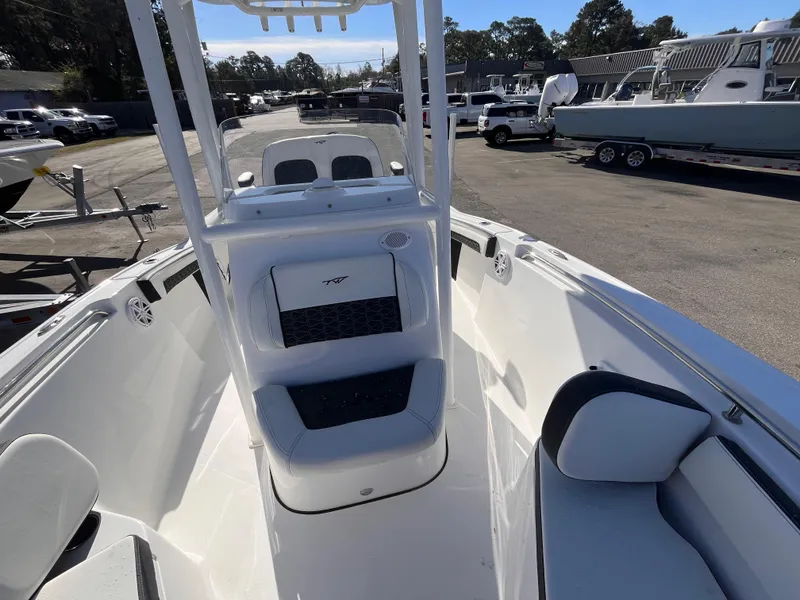 Slide: The Image of 2025 Tidewater 210 CC Adventure boat interior with seating and console, parked in a marina. - 12