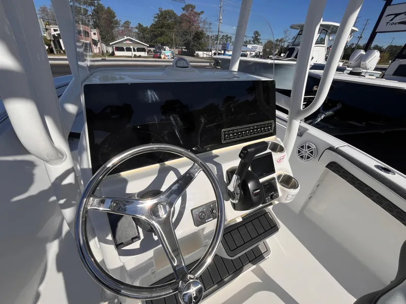 Slide: The Image of 2025 Tidewater 210 CC Adventure boat console with steering wheel and controls. - 8