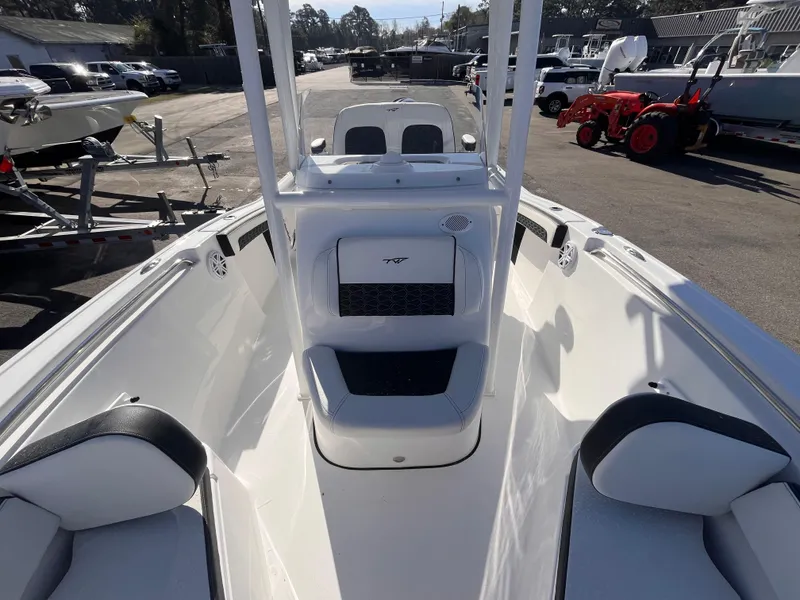 Slide: The Image of 2025 Tidewater 210 LXF boat interior with seating and console, parked outdoors. - 11