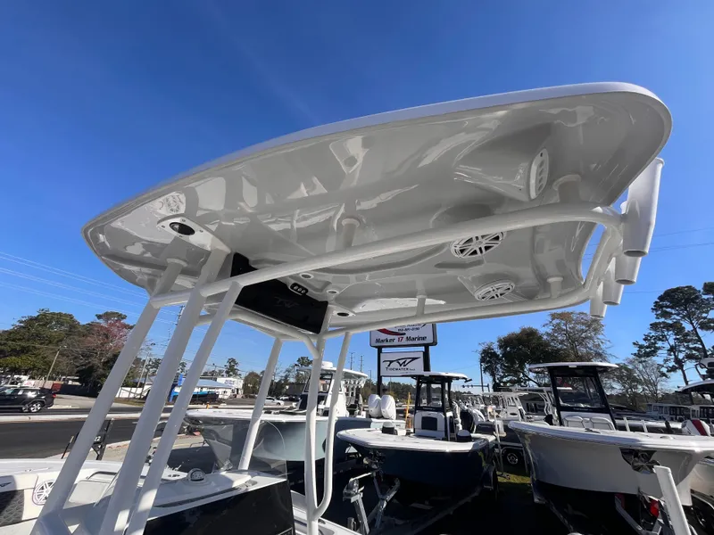 Slide: The Image of 2025 Tidewater 210 LXF boat with T-top, displayed outdoors under clear blue sky. - 9