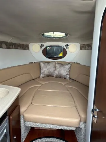 Slide: The Image of 2024 Crownline 270 CR cabin interior with beige seating and modern design. - 12
