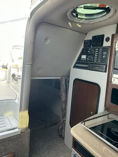 Slide: The Image of 2024 Crownline 270 CR cabin interior with control panel and compact kitchen area. - 13