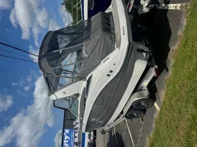 Slide: The Image of 2024 Crownline 270 CR boat on trailer, covered, parked outdoors. - 14