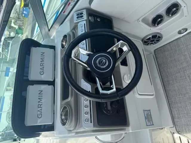 Slide: The Image of 2024 Crownline 270 CR boat dashboard with Garmin navigation system and steering wheel. - 17