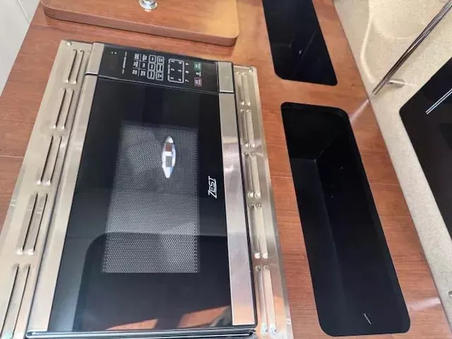 Slide: The Image of 2024 Crownline 270 CR boat interior with modern microwave and sleek countertop design. - 23