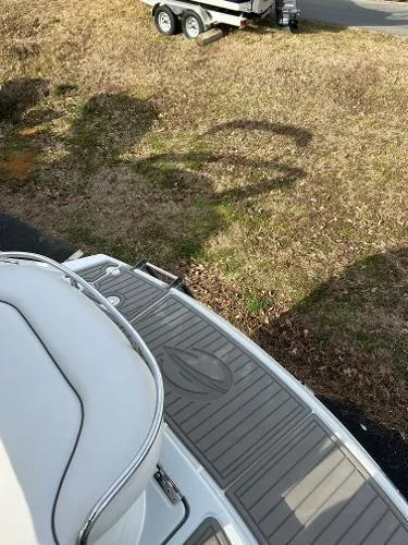 Slide: The Image of 2024 Crownline 270 CR boat with sleek deck design, parked on grass near a trailer. - 5