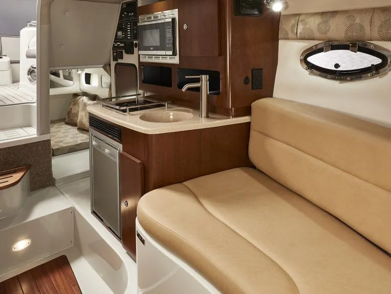 Slide: The Image of 2024 Crownline 280 CRX interior with kitchenette and seating area. - 14
